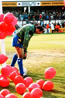 00403 Prints: Everton goalkeeper Neville Southall catches the ball with Eric Cantona jumping Manchester