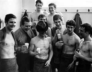 Everton hero, Johnny Morrisey, hides his face underneath his hat as the players celebrate
