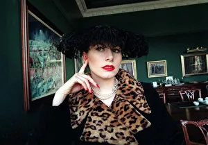 Animal Print Prints: Evita Fashion Model sitting down black coat with leopard skin collar feather hat black