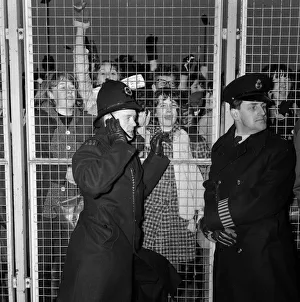 00106 Prints: Excited female Beatles fans deafen a young policeman keeping them at bay before
