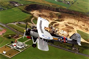 A Fairey Swordfish torpedo bomber aircraft flying over Souter Lighthouse