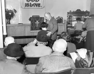 00086 Prints: Faith healer Mr. Alexander Albert Lunn with a patient during one of his services in 1956