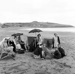 Coastal Prints: Families sheltering from the rain under blankets and umbrellas on the beach at Barry