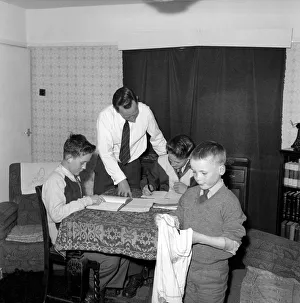 00068 Prints: Family Life: Mr. John Theakeston seen here helping his two sons with their school