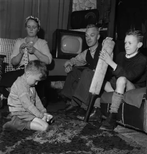 00014 Prints: Family Life in Oldham 1952. Mother sews while father watch his youngest son play