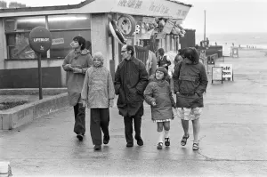 Cafe Prints: A family making the most of a walk on Hornsea sea front despite the weather conditions