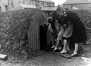 Underground Prints: A family wearing gas masks go into an Anderson air raid shelter