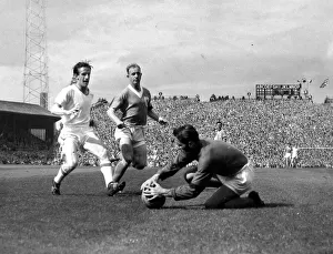 Farm (Blackpool) goes down to beat Dennis Viollet to the ball watched by Garrett