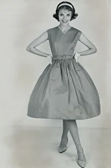 1950s Fashion Prints: Fashion 1950s Model wearing a pinafore dress with a full skirt and white gloves