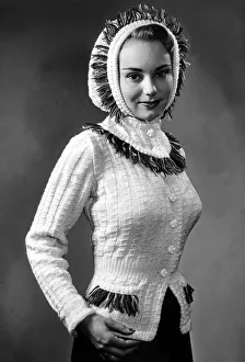 1950s Fashion Prints: Fashion December 1950 Model from 1950s wearing a fitted cream cardigan with detail