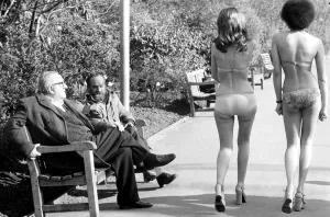 Fashion scene from Woolworth s. Two old men sitting on a park bench distracted by