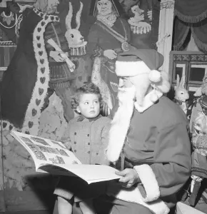 Custom Prints: Father Christmas seen here checking his naughty or nice book with a young client