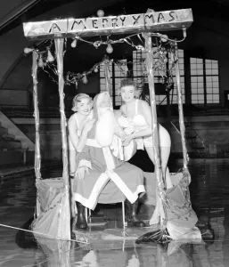 Father Christmas set adrift in a South London swimming pool with two bathing beauties