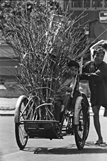 Images Dated 2nd February 1973: Father pushes his son on a cycle with a bundle of firewood through the streets of Saigon