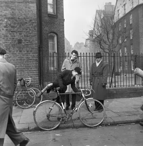 Cycling Prints: Father watches his son trying out cycles for sale at the flea market in Club Row