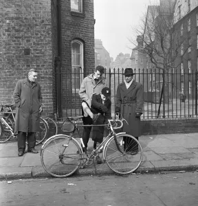 Father watches his son trying out cycles for sale at the flea market in Club Row
