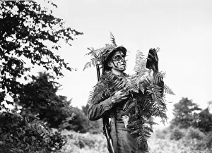 Camouflage Prints: Fieldcraft school student examines himself in glass to admire his camouflage during