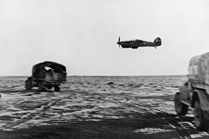 Middle East Prints: Fighter support planes circle round a New Zealand column in the Western Desert during