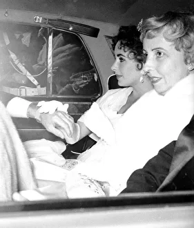 Film actress Elizabeth Taylor seated in the back of a car as she arrives for the opening