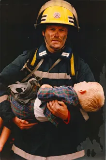 Firefighter Prints: A firefighter rescus a young boy from a fire 01 / 06 / 95 circa - posed by models