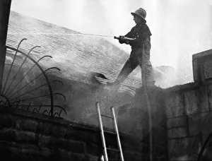 00074 Prints: Firefighters clambered over the roofs high above the city to tackle a blaze that
