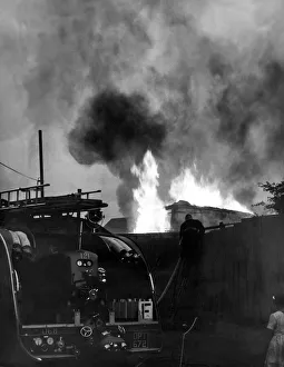 Hosepipe Prints: Firefighters contain a fire at a double-decker bus used as a storehouse at Washington