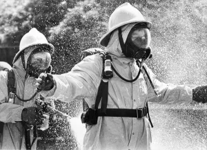 00074 Prints: Firefighters wearing protective suits fought a blaze in an asbestos unit at Poter Limited