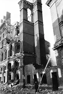 00007 Prints: A fireman hoses down smoking remains of a building in Southwark London after an air raid