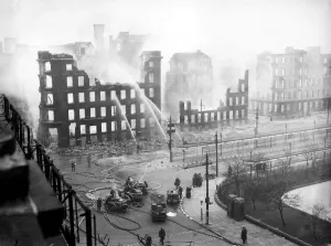 00204 Prints: Firemen play water from their hoses on to the smouldering remains of offices in