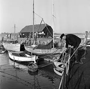 Fisherman Prints: A fisherman mooring his boat at Bosham on the West Sussex Seafront. January 1953