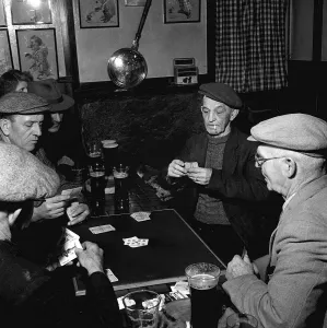 Fisherman around the table playing cards in a pub in St Ives in Cornwall February