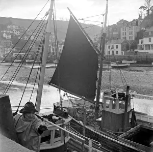 00021 Prints: Fisherman ties his boat up in the harbour at Looe, Cornwall. D782-002 Circa 1953