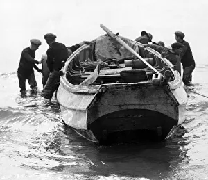 Fishermen prepare to beach their craft, after a morning spent fishing off the coast
