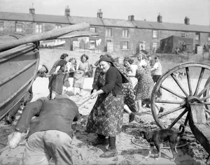 Fisherwomen of New Biggin, England hauling their boats ashore Women fulfilling