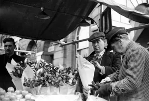 Serving Prints: The flower seller at Kingston market seen here serving a customer. Circa 1936