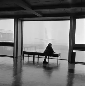 Foggy Prints: Fog delays at London Airport. A small boy passenger peers into the fog which grounded