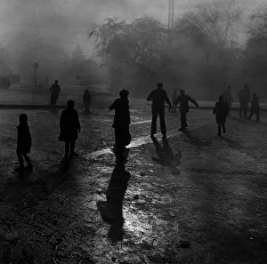 Fog and ice on Hampstead Heath. Boys sliding on the ice in the fog at Hampstead Heath