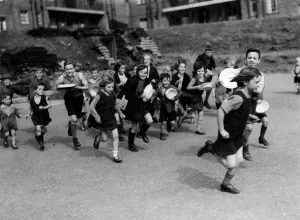 Plates Prints: Food glorious food. Children run for lunch at a communal feeding station