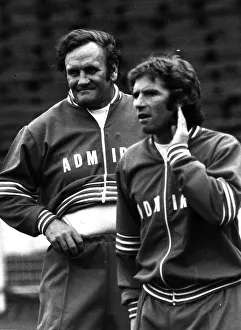 Football manager Don Revie with Alan Ball hand to ear wearing a track suit 1977