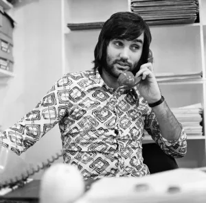 Phone Prints: Footballer George Best, business man on the phone sitting at desk in his shop