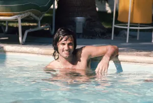 Footballer George Best relaxes in a swimming pool at his home in Palm Springs
