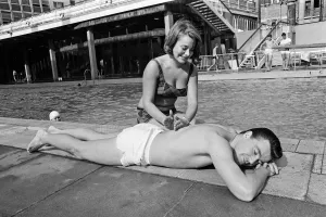 Footballer Johnny Byrne relaxing at oasis swimming baths. 21st August 1964