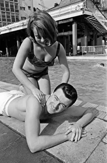 Footballer Johnny Byrne relaxing at oasis swimming baths. 21st August 1964