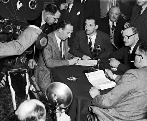 Transfer Prints: Footballer Tommy Lawton looks on as his new manager Jack Gibbons signs a contract after