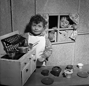 Four-year-old David McKnight and Jane Mathieson playing with their toy kitchen