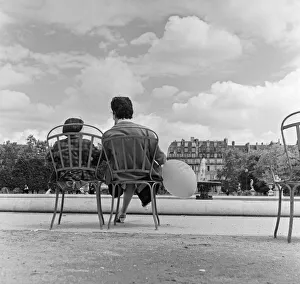 00538 Prints: France Paris -A Mother and Daughter sit in a park by a fountain during the state of