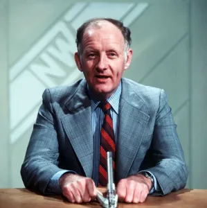 Frank Bough TV Presenter sitting at desk reading news
