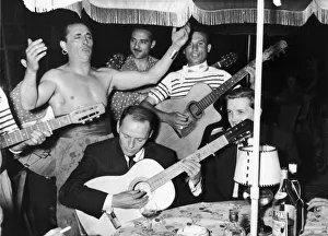Wine Prints: Frank Sinatra seen here playing the guitar during a gala party held by Grace Kelly in