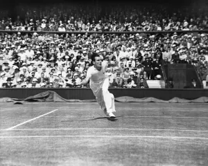 Fred Perry (GB) lunges to play a forehand at Wimbledon in the Mens semi finals again Jack