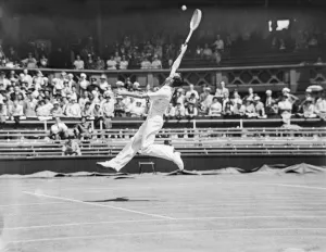 Shadow Prints: Fred Perry (GB) stretches high to reach the ball at the Wimbledon Tennis Championships